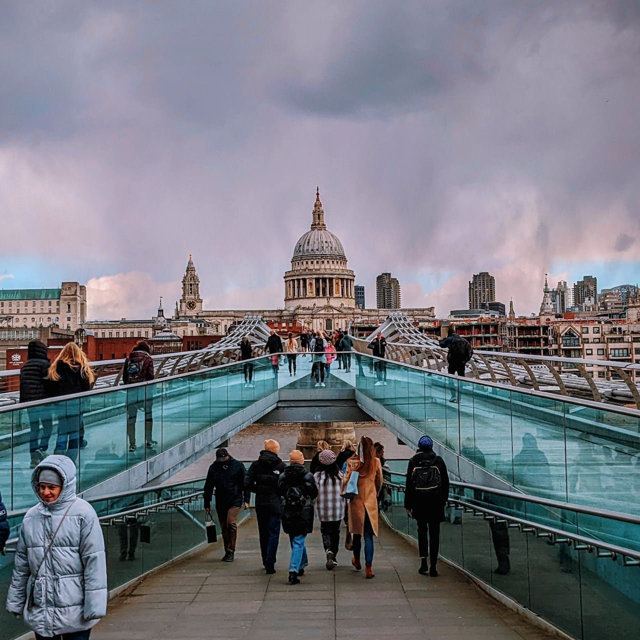 default-38 Crowds of people standing on a glass bridge leading to a large domed church.