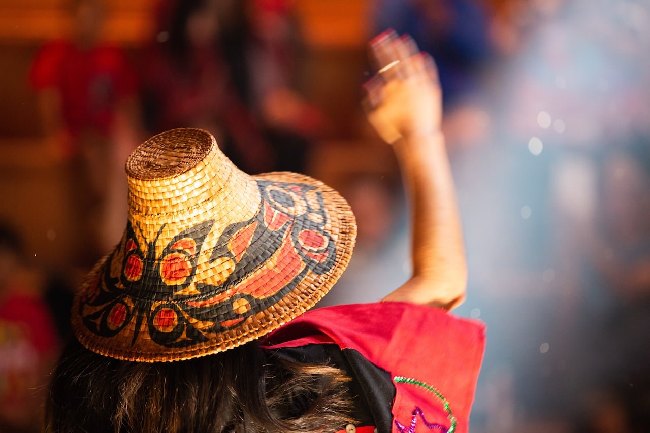 A woman in traditional attire with her arm raised.