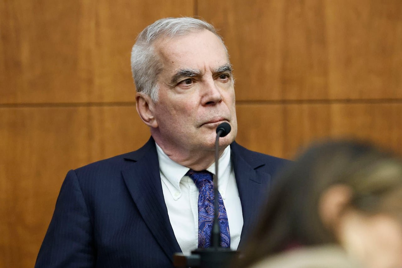 default-400 Serious-looking grey-haired man in a blue suit giving testimony in court